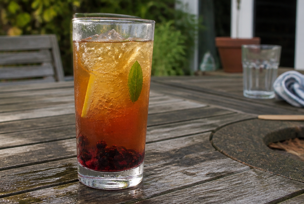 Blackberry Sulaimani fizz over ice on a wooden garden table
