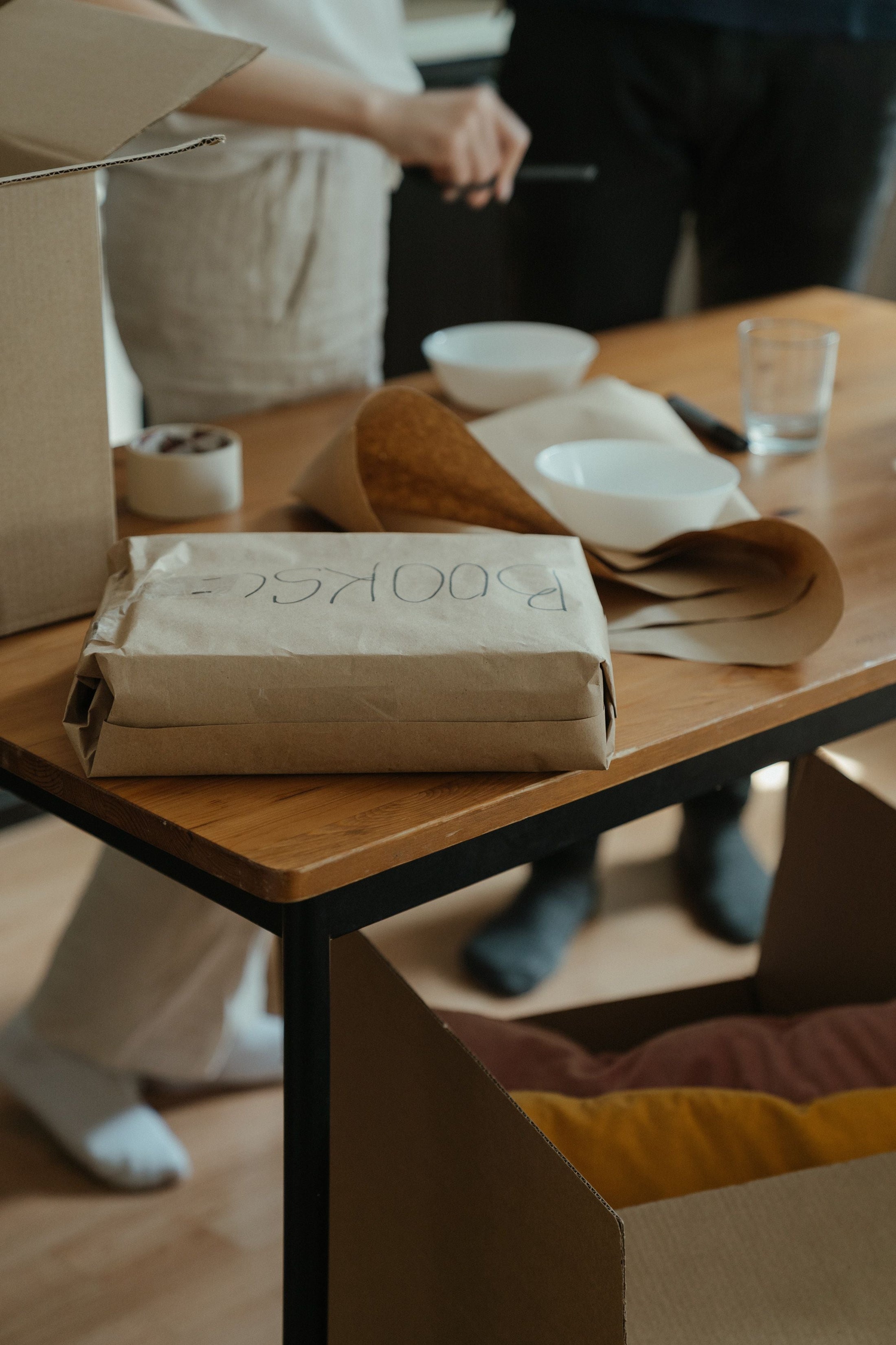 A tabletop scene with moving boxes and packing paper in a new home